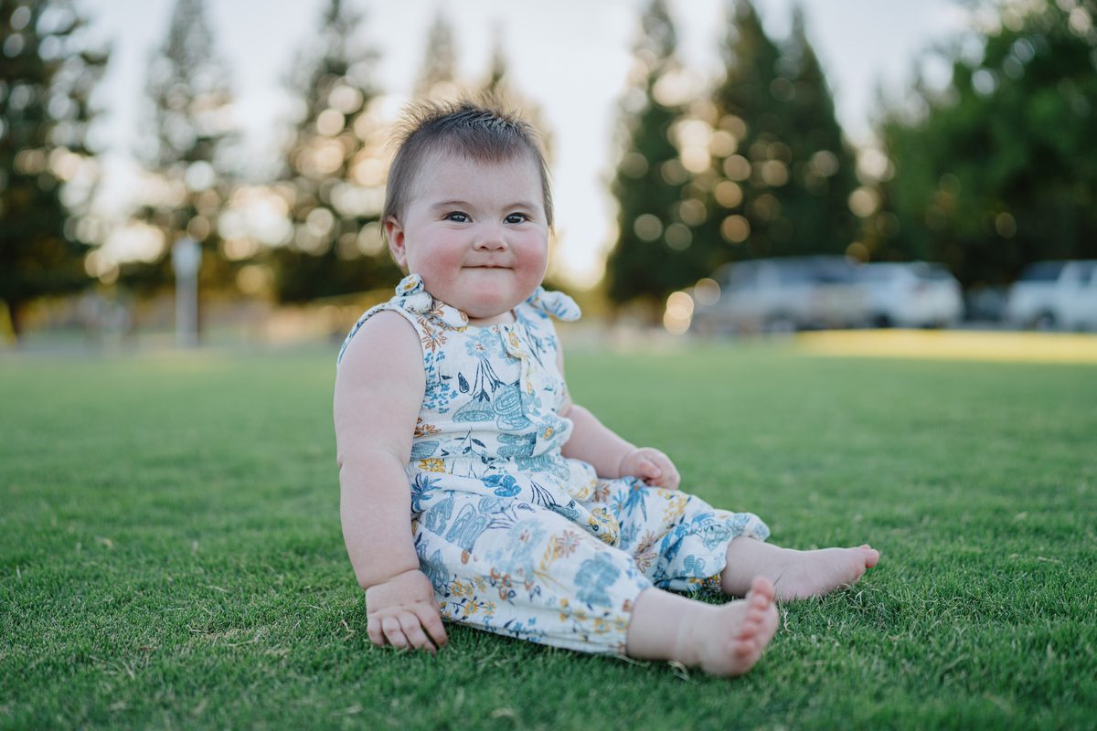 Baby sitting on grass at golden hour