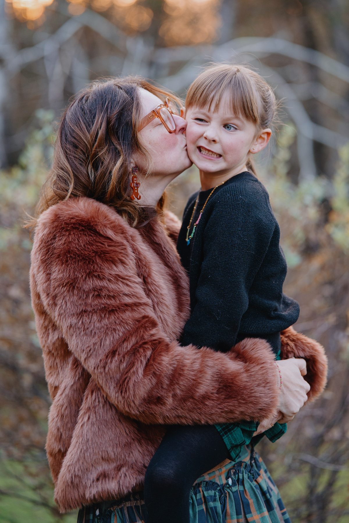 Mother kissing daughter who is laughing